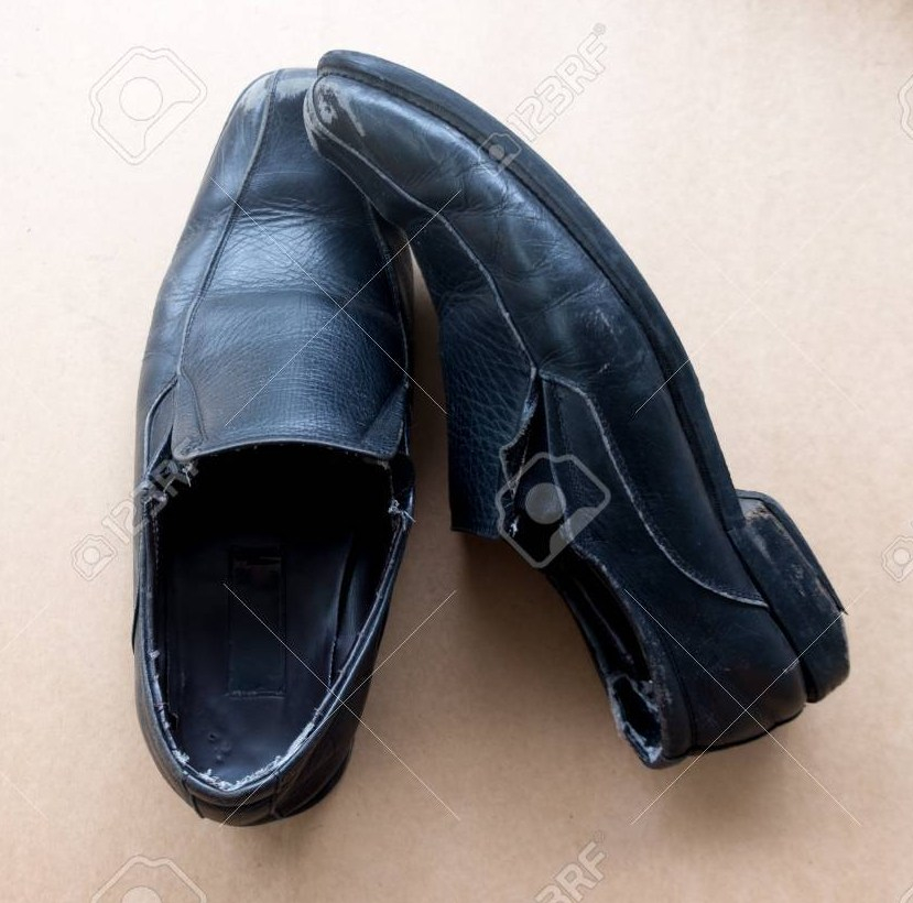 Old pair of used black leather shoes