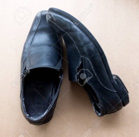 Old pair of used black leather shoes